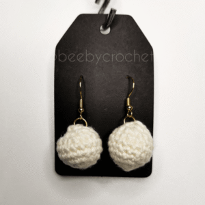 Valkoiset pallon muotoiset korvakorut, kultaisen värinen metalli, nikkelitön