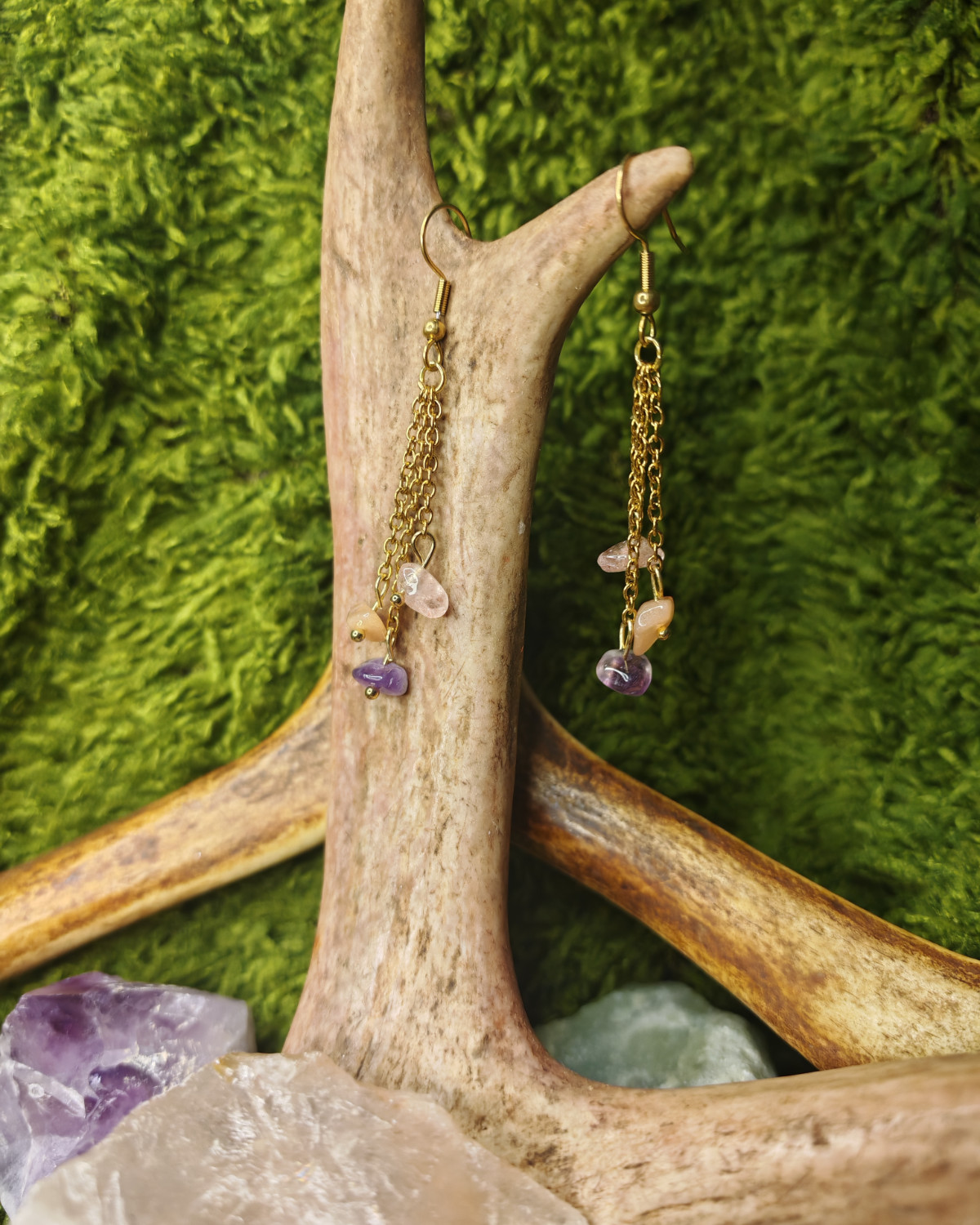 Roikkuvat korvakorut, kolme kullattua ohutta teräsketjua, joissa mansikkakvartsi, aurinkokivi ja ametisti.